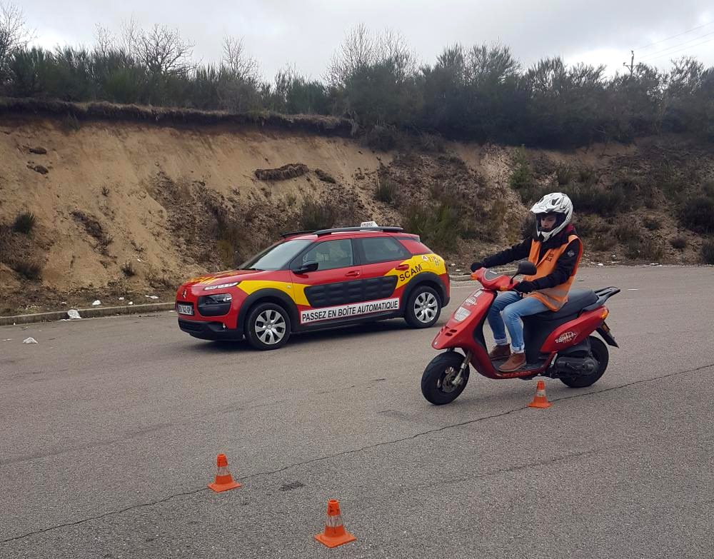 Élève à scooter et voiture école lors d'une leçon BSR