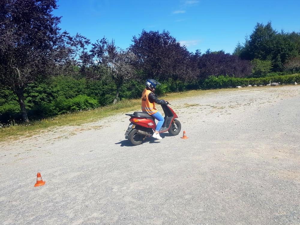 Élève en formation permis AM sur le scooter de l'école, piste avec plots